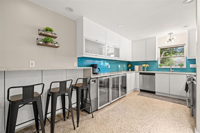 kitchen featuring a kitchen breakfast bar, stainless steel appliances, decorative backsplash, and white cabinets