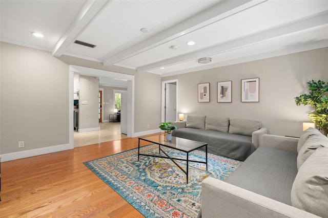 living room featuring beamed ceiling and light hardwood / wood-style flooring