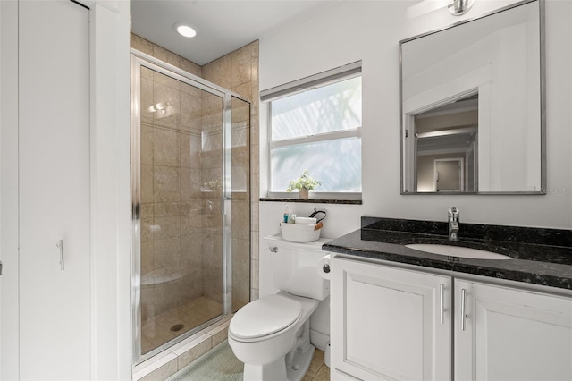 bathroom with tile patterned floors, toilet, a shower with shower door, and vanity