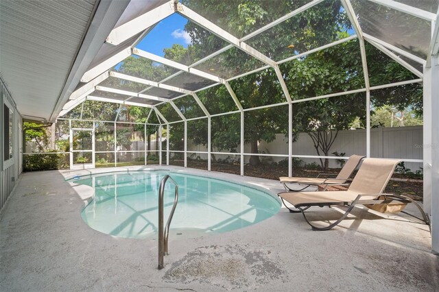 view of swimming pool featuring a patio area and a lanai