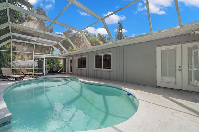 view of pool with glass enclosure and a patio area