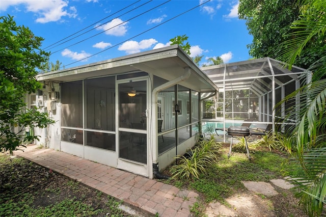 back of property featuring glass enclosure and a sunroom