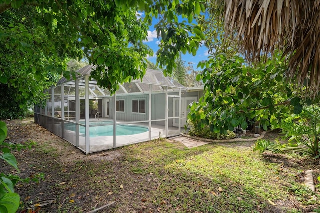 view of pool featuring glass enclosure and a patio