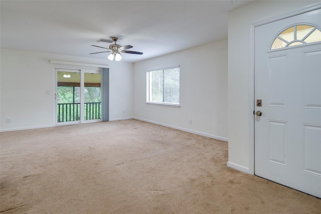 carpeted entryway with ceiling fan