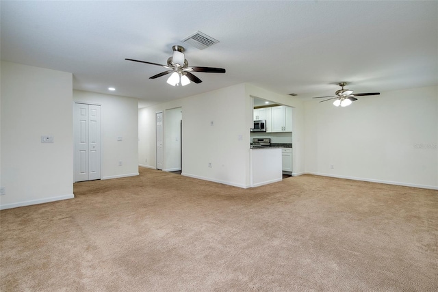 unfurnished living room with ceiling fan and light carpet