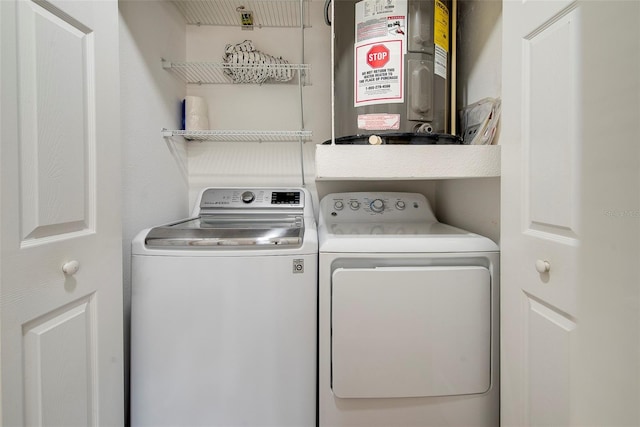 clothes washing area featuring washing machine and dryer and electric water heater