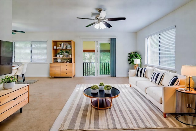 carpeted living room featuring ceiling fan