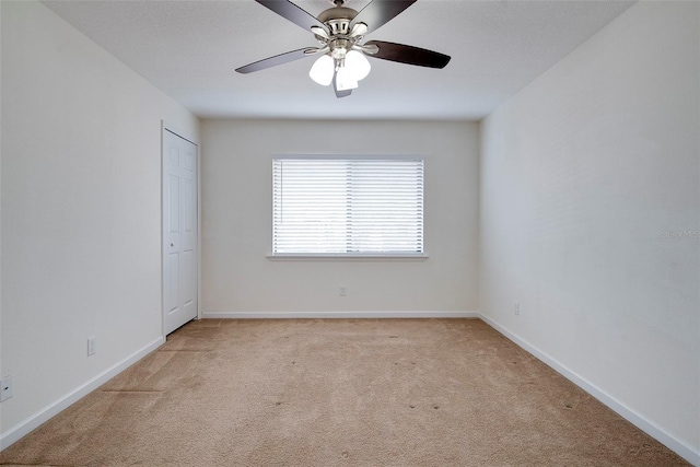 carpeted empty room featuring ceiling fan