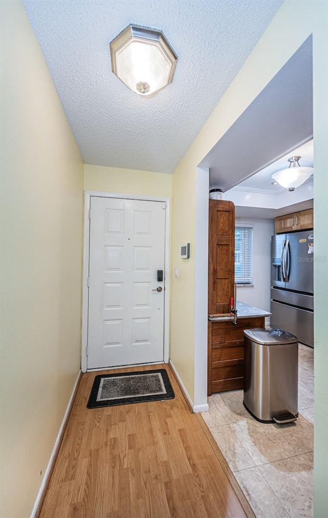 foyer with a textured ceiling and light hardwood / wood-style floors