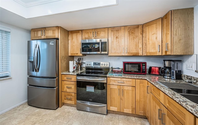 kitchen with light tile patterned flooring, appliances with stainless steel finishes, stone counters, decorative backsplash, and crown molding