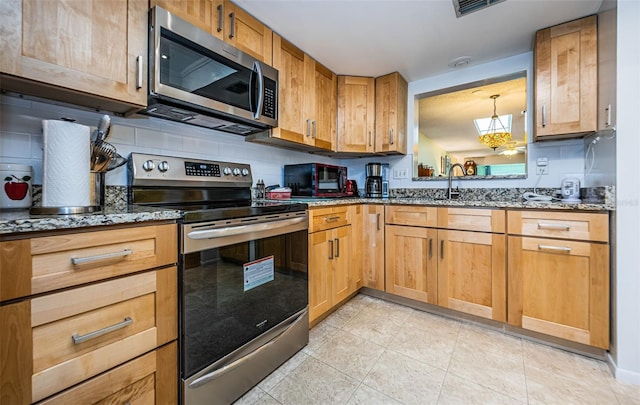 kitchen featuring decorative backsplash, dark stone countertops, and stainless steel appliances