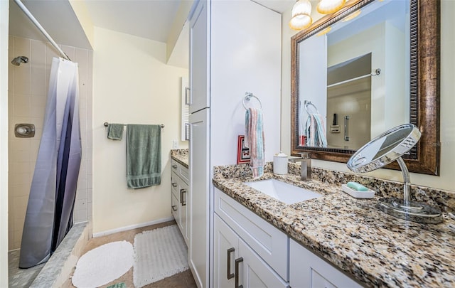 bathroom with tile patterned flooring, vanity, and walk in shower