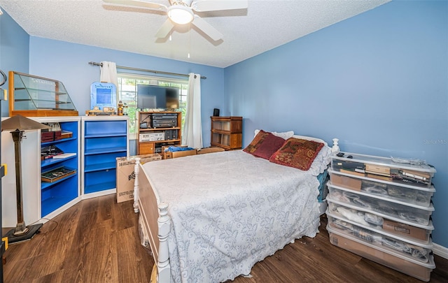 bedroom with a textured ceiling, ceiling fan, and dark hardwood / wood-style floors