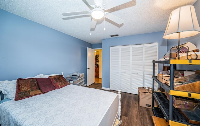 bedroom with a textured ceiling, a closet, ceiling fan, and dark hardwood / wood-style flooring