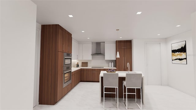 kitchen featuring wall chimney exhaust hood, a kitchen breakfast bar, a center island, and double oven