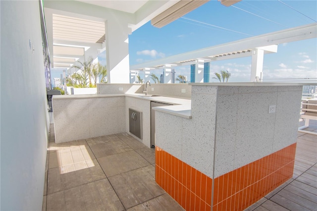 view of patio featuring an outdoor kitchen, a sink, and outdoor wet bar