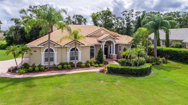 mediterranean / spanish home featuring a front lawn