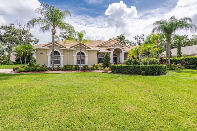 mediterranean / spanish-style home featuring a front yard