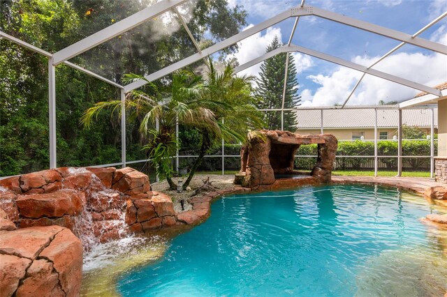 view of swimming pool featuring glass enclosure and pool water feature