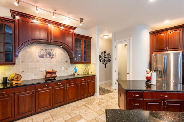 kitchen with stainless steel fridge with ice dispenser and decorative backsplash