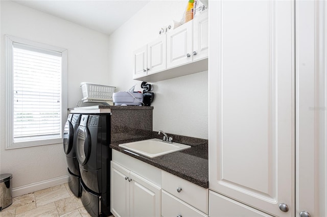 laundry room featuring cabinets, washing machine and clothes dryer, and sink