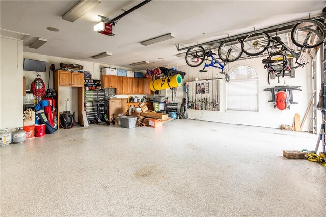 garage featuring a garage door opener and a workshop area