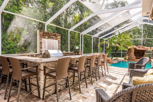 view of patio / terrace with area for grilling, a bar, and a lanai