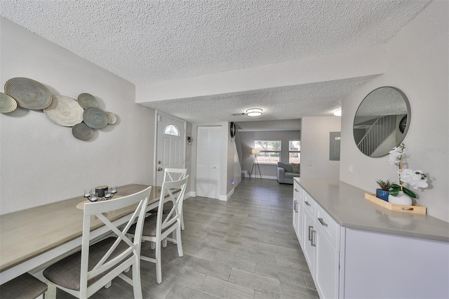 dining area with light hardwood / wood-style floors and a textured ceiling