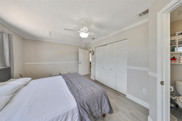 bedroom with a closet, ceiling fan, light hardwood / wood-style floors, and a textured ceiling