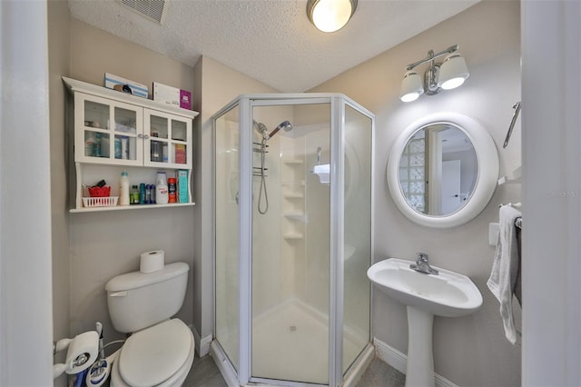 bathroom featuring toilet, walk in shower, and a textured ceiling