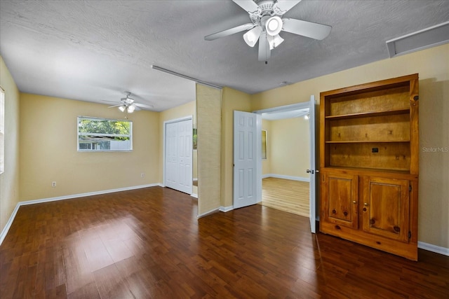 spare room with a textured ceiling, ceiling fan, and dark hardwood / wood-style floors