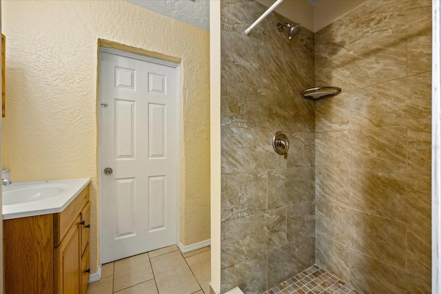 bathroom with tile patterned floors, vanity, and a tile shower