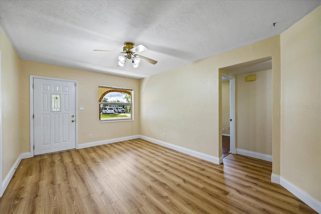 interior space with ceiling fan, light hardwood / wood-style floors, and a textured ceiling