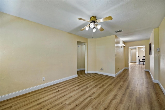 spare room featuring a textured ceiling, light hardwood / wood-style flooring, and ceiling fan