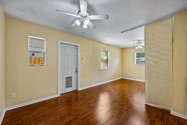 unfurnished room featuring a textured ceiling, ceiling fan, and dark hardwood / wood-style floors