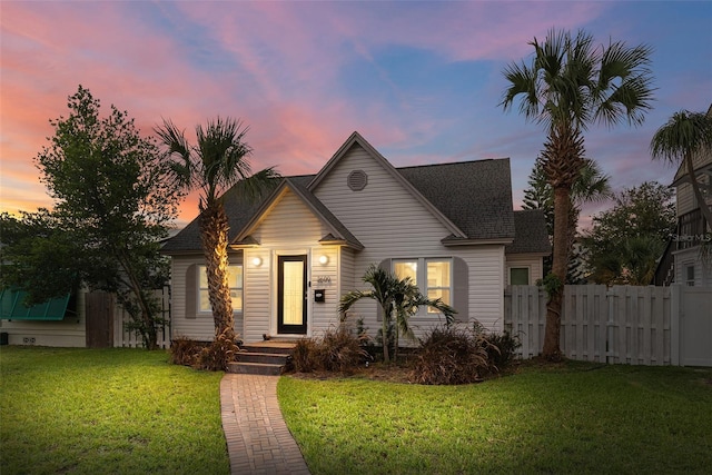 view of front of house with a yard and fence