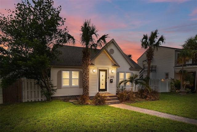 view of front of property featuring a front lawn and fence