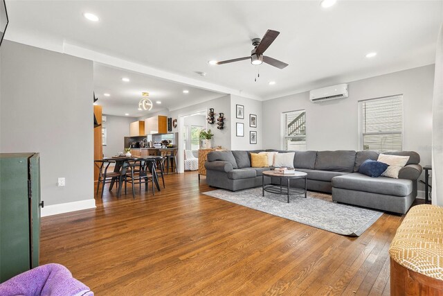 living room with dark wood-type flooring, ceiling fan, and a wall mounted AC