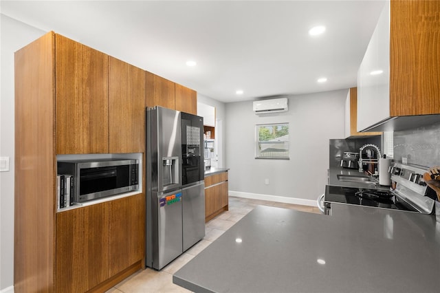 kitchen with tasteful backsplash, light tile patterned floors, sink, appliances with stainless steel finishes, and an AC wall unit