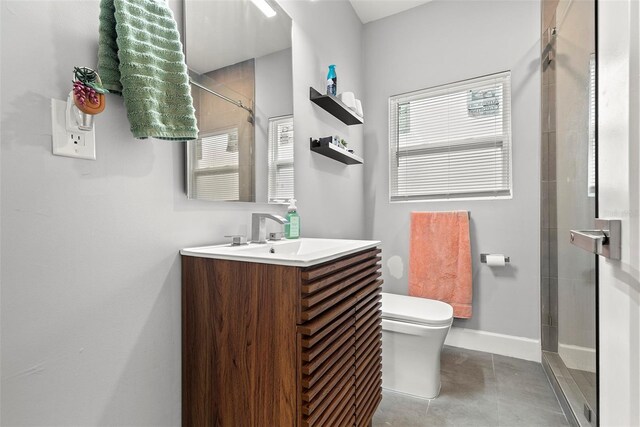 bathroom featuring vanity, toilet, a shower with shower door, and tile patterned floors