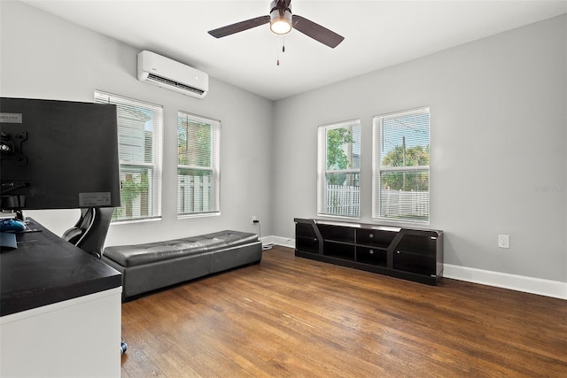 office space featuring a ceiling fan, baseboards, wood finished floors, and a wall mounted air conditioner