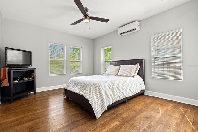 bedroom with ceiling fan, dark hardwood / wood-style flooring, and a wall mounted air conditioner