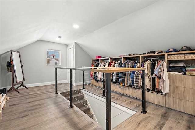 spacious closet with hardwood / wood-style flooring and vaulted ceiling