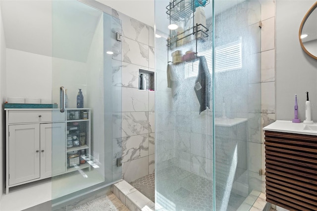 bathroom featuring a shower with door and vanity