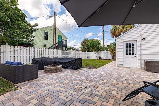 view of patio featuring an outdoor fire pit, a fenced backyard, and an outdoor structure