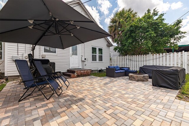 view of patio with an outdoor living space with a fire pit and a grill