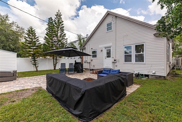 rear view of property featuring fence, an outdoor living space, a lawn, and a patio