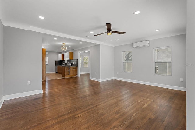 unfurnished living room with baseboards, dark wood-type flooring, a wall mounted AC, and recessed lighting