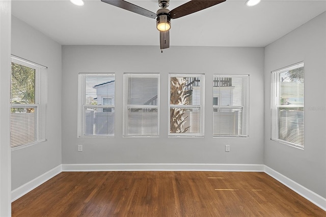 spare room featuring ceiling fan, baseboards, and wood finished floors