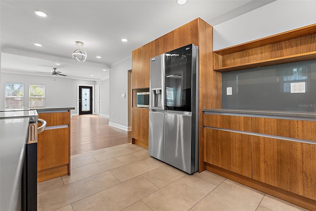 kitchen featuring stainless steel appliances, brown cabinetry, and modern cabinets